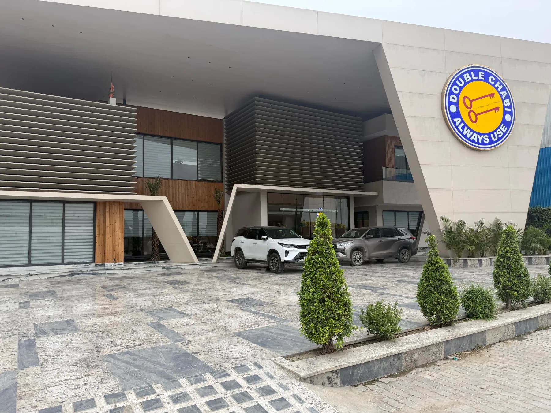 The main entrance canopy of the Double Chabi facility, with the company emblem above the doors and the mill building behind.